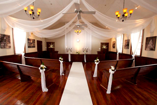 Custom ceiling treatments and backdrop in white chiffon by W Drapings for an intimate wedding ceremony at Winter Park Wedding Chapel. Photo by Winter Park Photography.